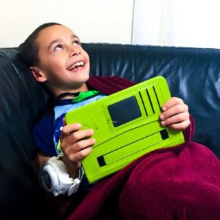 Boy is laughing with a tablet