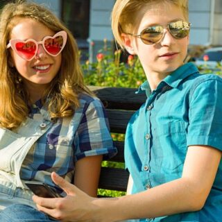 Two teens in sunglasses looking up