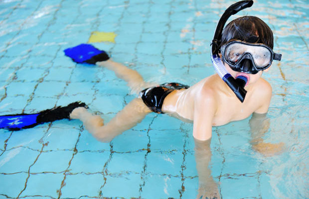 boy swims on shallow