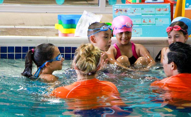 Group of boys and girls in Goldfish swim pool having a conversation