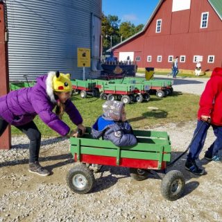 Lafayette Exploration Acres pushing a cart with a child