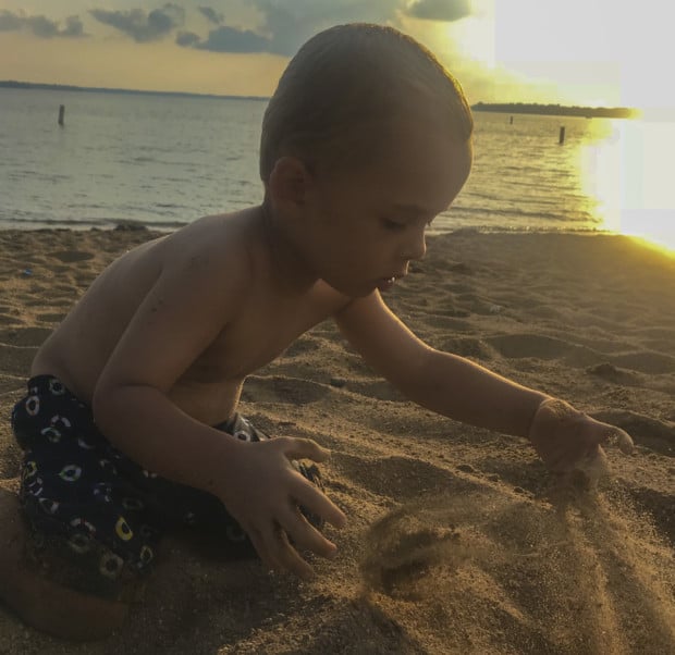 Boy plays in sand on beach in Clear Lake Iowa