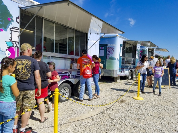 Food trucks at girl standing straw pile Johnson County Indiana Festival Country