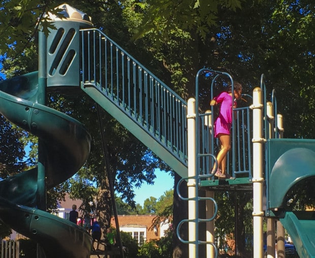 Girl plays on playground in clear lake Iowa