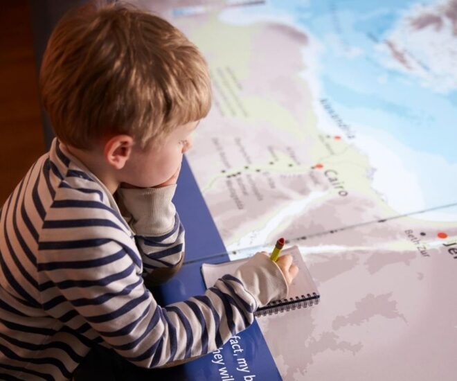 Boy looks over map and taking notes