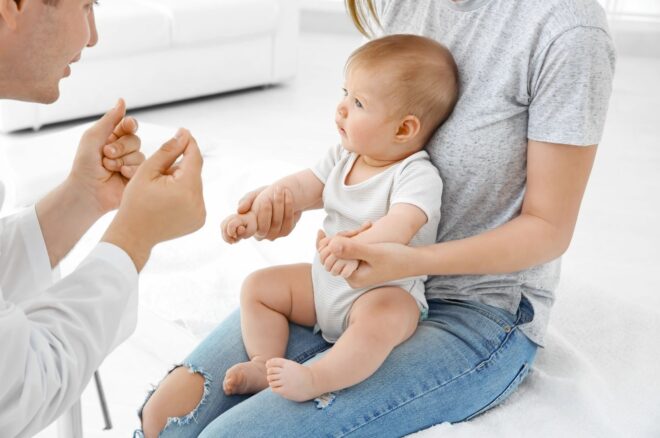 doctor is talking to baby sitting on mom's lap
